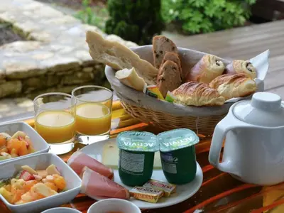 a table with a basket of bread and glasses of orange juice at Nature & Design in Bonifacio
