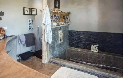 a room with a bath tub with a stone wall at 3 Bedroom Awesome Home In Calenzana in Calenzana