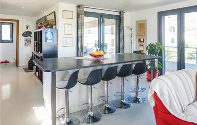 a kitchen with a bar with stools at 3 Bedroom Awesome Home In Calenzana in Calenzana