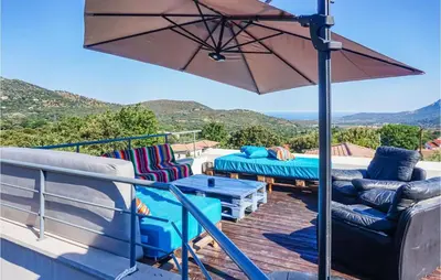 a patio with a table and chairs and an umbrella at 3 Bedroom Awesome Home In Calenzana in Calenzana