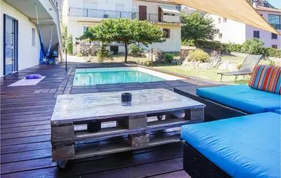 a coffee table on a deck next to a pool at 3 Bedroom Awesome Home In Calenzana in Calenzana
