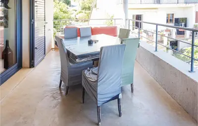 a table and chairs on the balcony of a house at 3 Bedroom Awesome Home In Calenzana in Calenzana