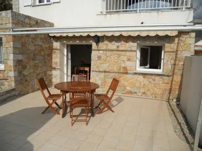 a wooden table and chairs on a patio at Gites-Sassone in Sagone