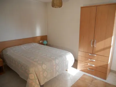 a bedroom with a bed and a wooden cabinet at Gites-Sassone in Sagone