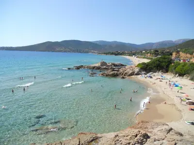 a group of people in the water at a beach at Gites-Sassone in Sagone