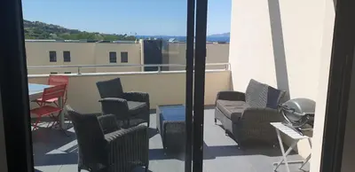 a balcony with chairs and a table on a building at Appartement neuf T2 centre de Porticcio in Porticcio