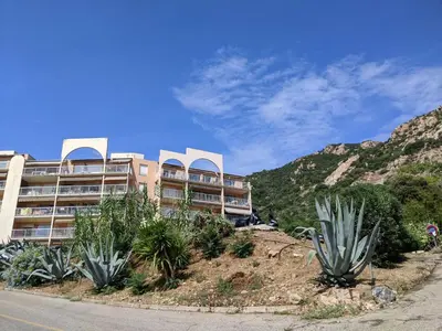 a building on the side of a hill with plants at Studio 4 pers terrasse vue mer in Ajaccio