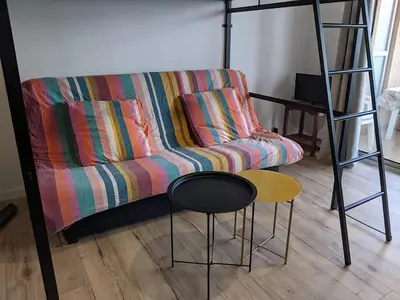 a living room with a couch and a ladder and stool at Studio 4 pers terrasse vue mer in Ajaccio