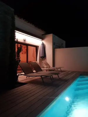 a couch and a table on a wooden deck at Villa HOME HOLIDAY à Cala Rossa in Lecci