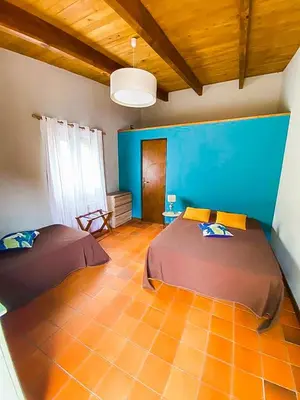 a bedroom with two beds and a blue wall at Auberge De La Foret Bonifatu in Calenzana
