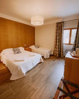 a hotel room with two beds and a window at Auberge De La Foret Bonifatu in Calenzana