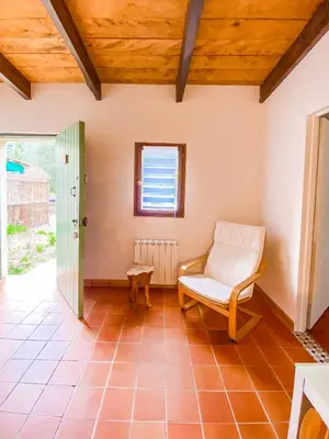 a living room with a chair and a window at Auberge De La Foret Bonifatu in Calenzana
