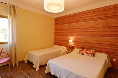 two beds in a room with wooden walls at Auberge De La Foret Bonifatu in Calenzana
