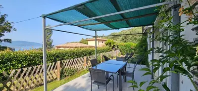 a blue table and chairs under a pergola at Mini villa T2 climatisée, vue mer, cosy & moderne in Olmeto