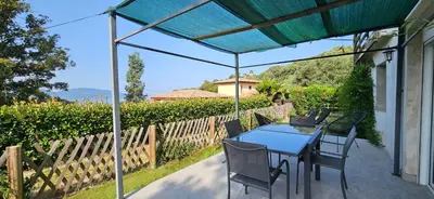 a patio with a blue table and chairs and a fence at Mini villa T2 climatisée, vue mer, cosy & moderne in Olmeto