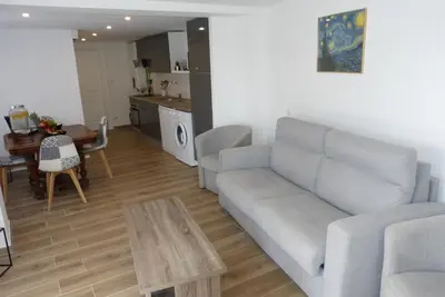 a living room with a couch and a table at Mini villa T2 climatisée, vue mer, cosy & moderne in Olmeto