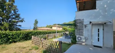 a house with a white door and a fence at Mini villa T2 climatisée, vue mer, cosy & moderne in Olmeto