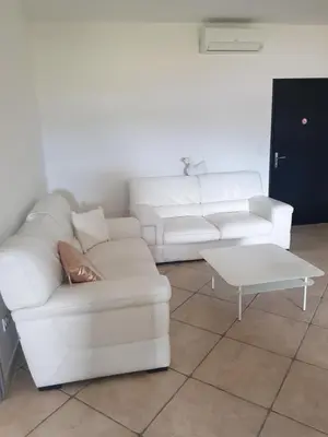 a living room with a white couch and a coffee table at appartement tra mare e monti in Ghisonaccia