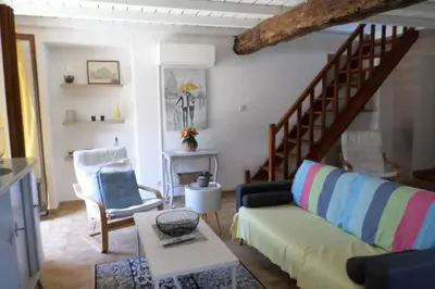 a living room with a couch and a stair case at Appartement de charme entre mer et montagne in Sollacaro