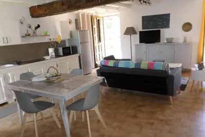 a living room with a table and a couch at Appartement de charme entre mer et montagne in Sollacaro
