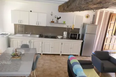 a kitchen with a table and a kitchen with a refrigerator at Appartement de charme entre mer et montagne in Sollacaro
