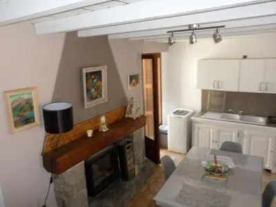 a living room with a fireplace and a dining table at Appartement de charme entre mer et montagne in Sollacaro