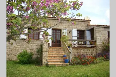 a brick house with a staircase in front of it at Maison de charme proche mer en Corse du Sud in Sollacaro
