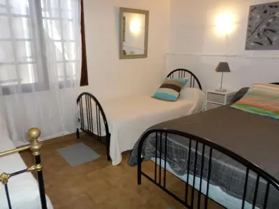 a bedroom with two beds and a mirror on the wall at Maison de charme proche mer en Corse du Sud in Sollacaro