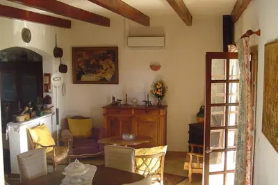 a living room with a table and a dining room at Maison de charme proche mer en Corse du Sud in Sollacaro