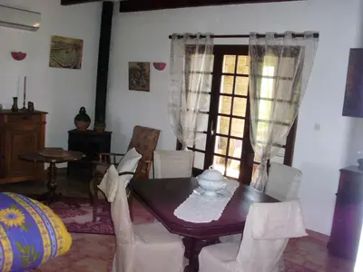 a dining room with a table and chairs and a window at Maison de charme proche mer en Corse du Sud in Sollacaro