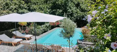 a swimming pool with an umbrella and chairs and a table and sidx sidx at U Vechju Mulinu in Ortiporio
