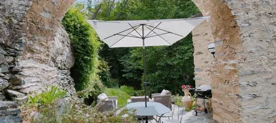 a patio with a table and an umbrella at U Vechju Mulinu in Ortiporio