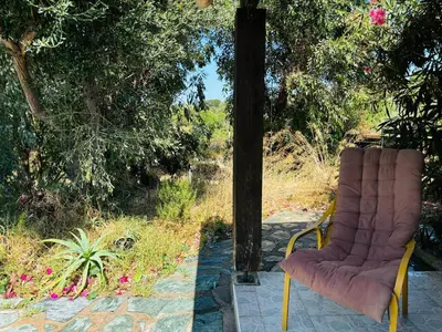 a chair sitting on a patio in front of a window at A Pineta in Porticcio