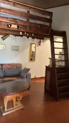 a living room with a couch and a stair case at A Pineta in Porticcio