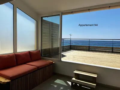 a living room with a couch and a view of the ocean at Appartements résidence Harmonie vue mer in Porticcio