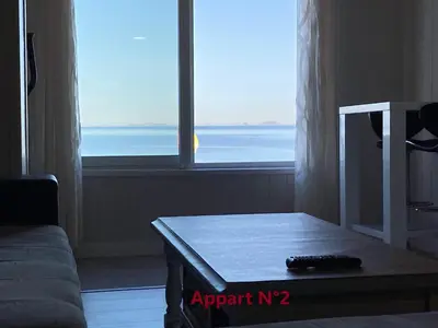 a living room with a table in front of a window at Appartements résidence Harmonie vue mer in Porticcio