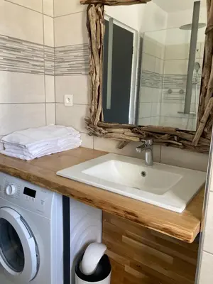 a bathroom with a sink and a washing machine at Appartements résidence Harmonie vue mer in Porticcio