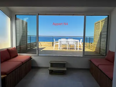 a room with a view of the ocean from a balcony at Appartements résidence Harmonie vue mer in Porticcio