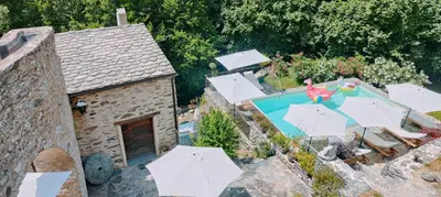an aerial view of a house with a swimming pool with umbrellas at U Caseddu 