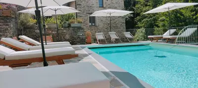 a swimming pool with chairs and umbrellas next to a swimming pool at U Caseddu 