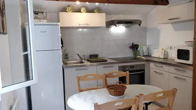 a kitchen with a table and chairs and a white refrigerator at Casetta in Ortiporio