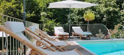 a group of chairs and an umbrella next to a pool at Casetta in Ortiporio