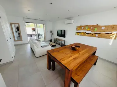 a living room with a wooden table and a couch at Villa Santa Giulia in Porto-Vecchio
