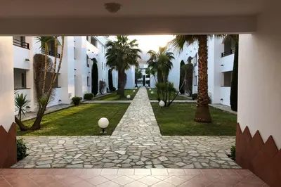 a courtyard with palm trees in a building at Moriani-Plage : Résidence en bord de mer in San-Nicolao