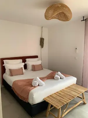 a bedroom with a large bed with towels on it at Chambres d’hôtes Casarena in Porto-Vecchio