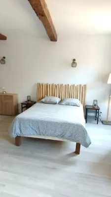 a bedroom with a bed with a wooden headboard at studio cosy centre ville in Ajaccio