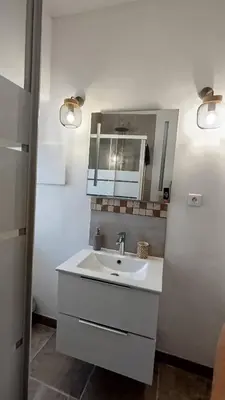 a white bathroom with a sink and a mirror at studio cosy centre ville in Ajaccio
