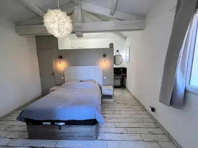 a bedroom with a bed and a chandelier at Joli F1 en bordure d'Ajaccio in Ajaccio