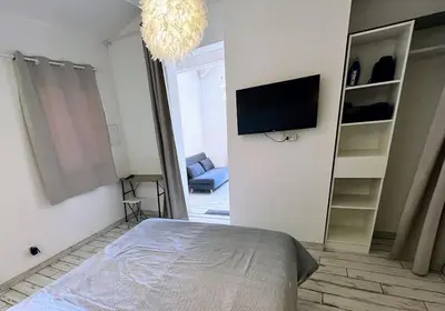 a bedroom with a bed and a flat screen tv at Joli F1 en bordure d'Ajaccio in Ajaccio
