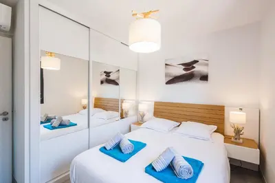 a bedroom with two beds and a mirror at Petra d'Oro Villa Palombaggia in Porto-Vecchio